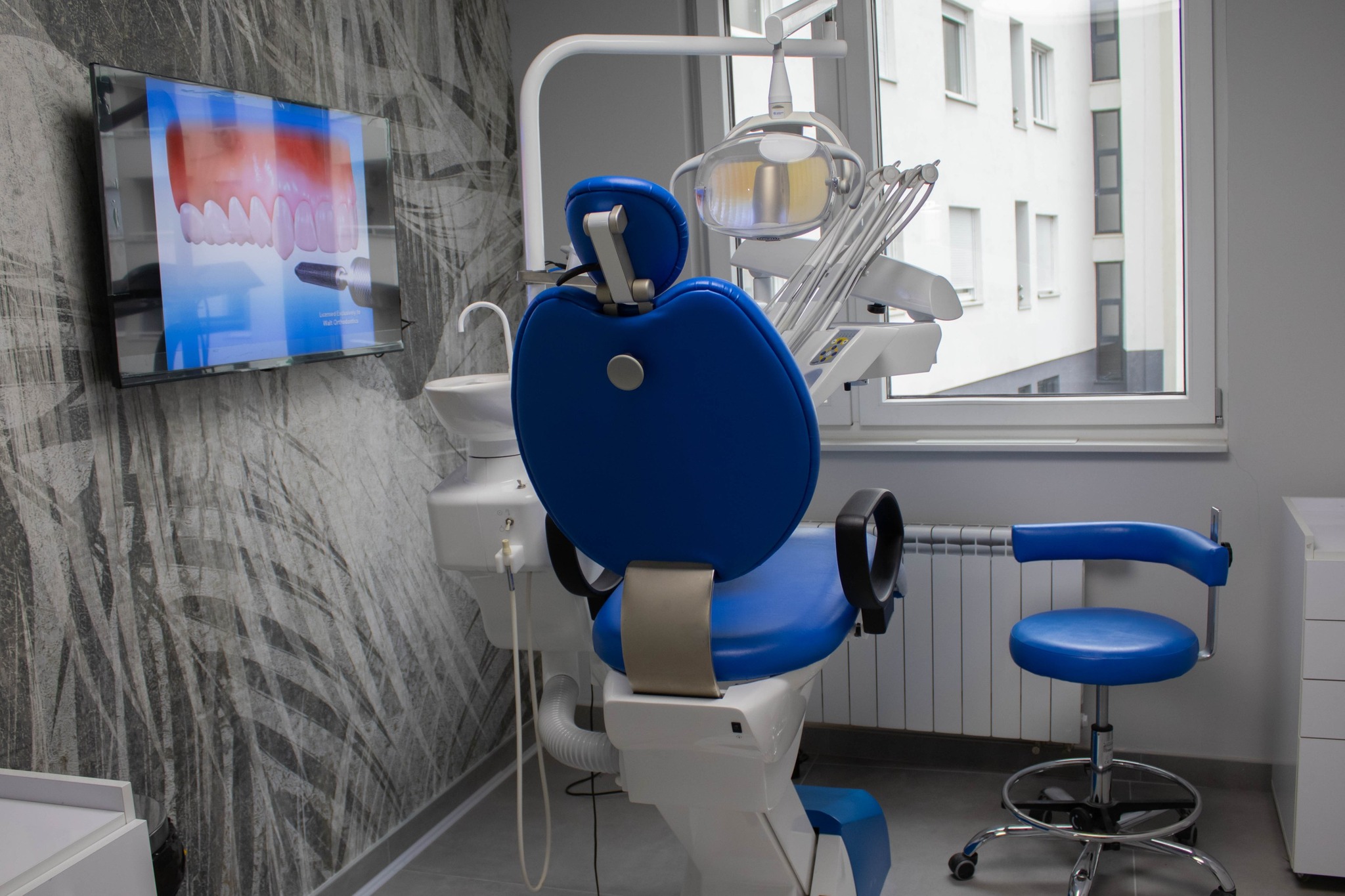 Dental chair with blue upholstery and monitoring equipment
